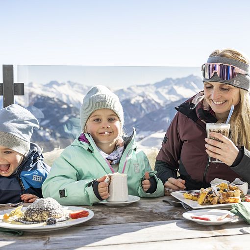 Familie beim Essen auf Skihütte