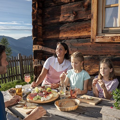 Familie beim Brettljause essen