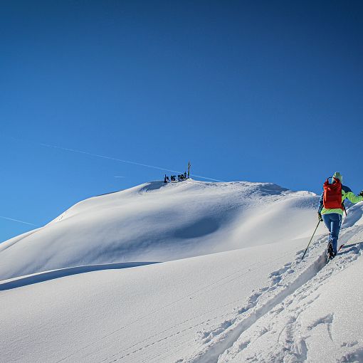 Skitourengeher Aufstieg zum Gipfelkreuz