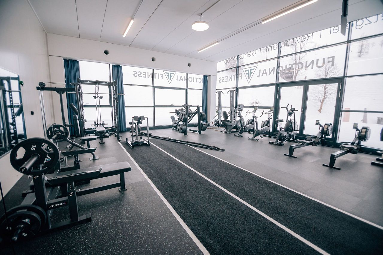 Heller, großzügiger Functional-Fitness-Bereich mit verschiedenen Trainingsgeräten.