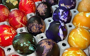 Bunt gefärbte Ostereier in den Farben rot, grün, blau, violett und gelb liegen in einer Schachtel