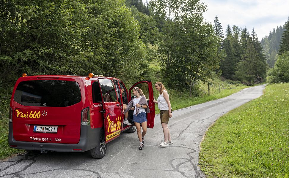 Mehrere Wanderer steigen aus dem Wandertaxi Großarltal aus um ihre Wanderung im Tal der Almen zu starten.