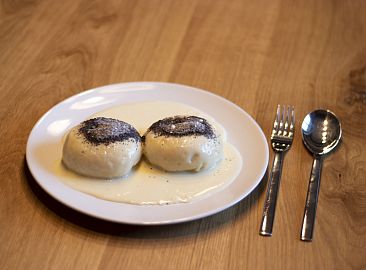 Die Germknödel stehen mit Mohn bestreut am Tisch.